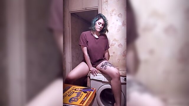Tattooed teen plays with her trimmed pussy on the washing machine