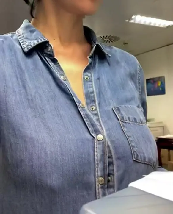 exhibant ses énormes seins au bureau