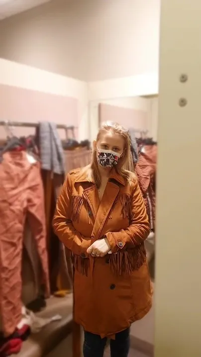 Du siehst ein Mädchen in einem Mantel in einer Umkleidekabine in einem Geschäft und plötzlich....Tadam!
