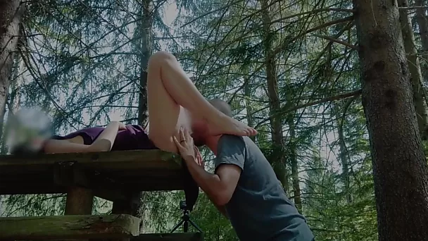 Hacer el amor apasionadamente en una mesa de picnic en el bosque