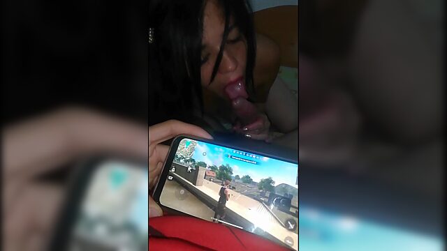 Dude playing videogames on his phone while his horny gf blows his cock