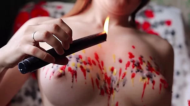 Une sous-adolescente décore ses seins parfaits avec de la cire de bougie