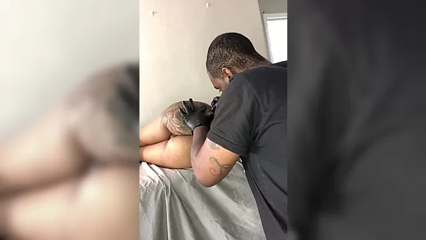 Naked ebony is getting a tattoo