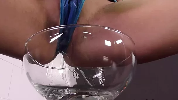 La beauté chaude fait pipi dans un verre à vin et joue en solo avec un jouet