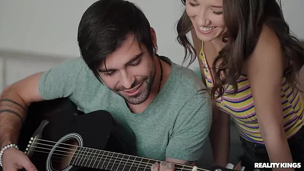 He plays the guitar and with her delicious pussy and small perky tits