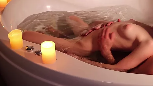 Sesso romantico in una vasca idromassaggio a lume di candela con un'incredibile rossa snella e sexy