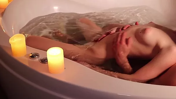 Sexo romântico em uma jacuzzi à luz de velas com uma ruiva esbelta e sexy