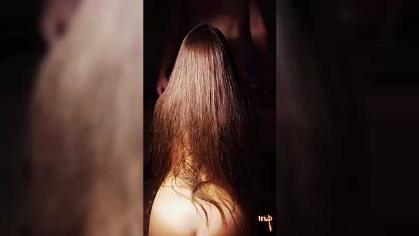 Wspaniała brunetka z długimi włosami robi soczystego loda na klęczkach.
