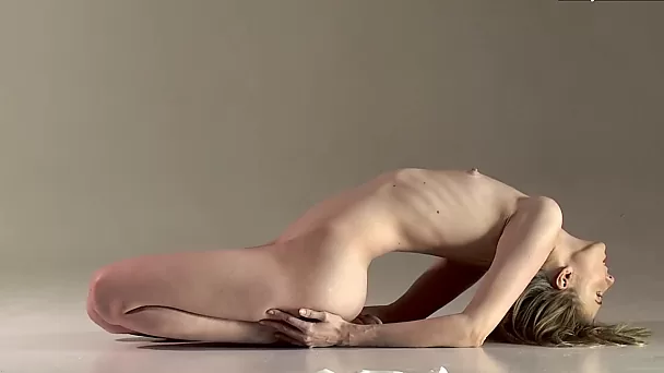Impresionante rubia rusa muestra la flexibilidad de su cuerpo delgado y muestra sus agujeros