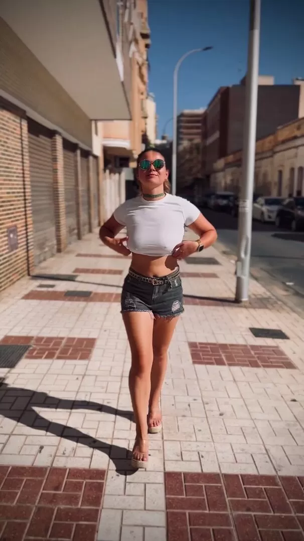 Puta sin sujetador mostrando sus tetas en la calle.