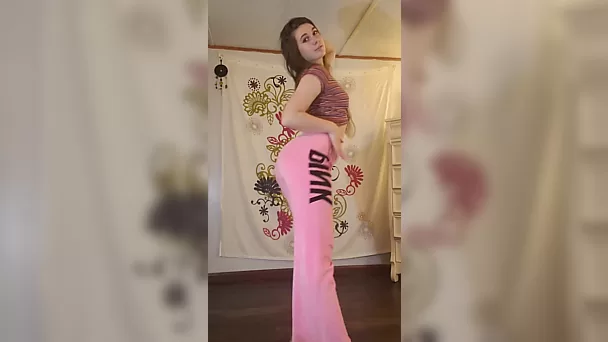 Nena con pantalones rosas tiene un espectáculo de striptease en un rodaje privado
