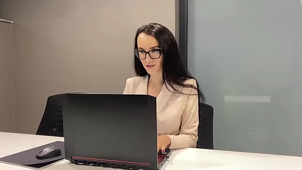 La ragazza dell'ufficio si arrapa sul posto di lavoro e strofina il clitoride sotto il tavolo