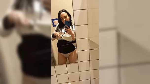 Une amatrice brune tourne une vidéo en solo et se frotte la chatte dans les toilettes publiques